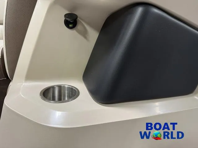 Slide: The Image of 2025 Tahoe LTZ 2385 Swingback interior detail with cup holder and Boat World logo. - 28