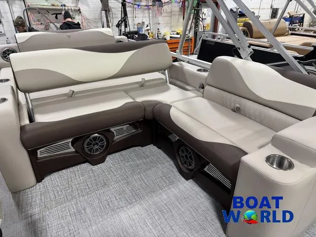 Slide: The Image of 2025 Tahoe LTZ 2385 Swingback interior with beige and brown seating, Boat World logo. - 32