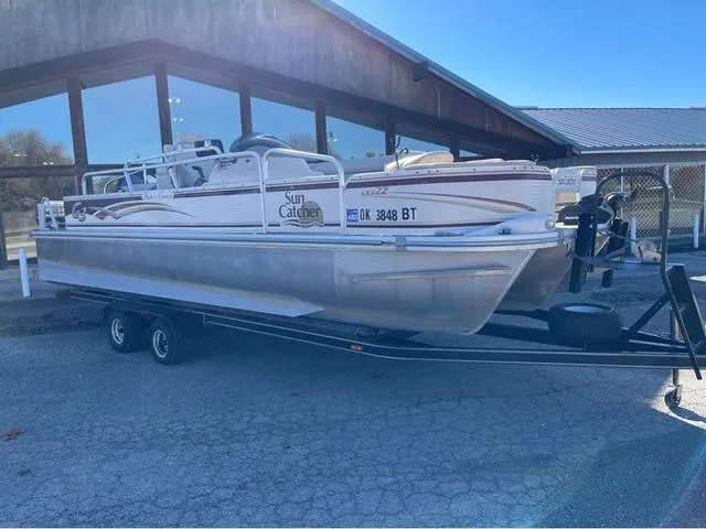 Slide: The Image of 2009 G3 LX 322FC pontoon boat on trailer, parked outside a building. - 1
