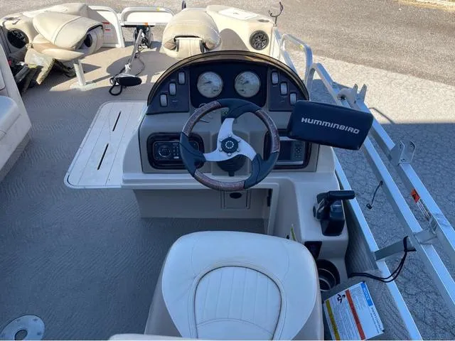 Slide: The Image of 2009 G3 LX 322FC boat dashboard with steering wheel and Humminbird fish finder. - 12