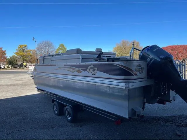 Slide: The Image of 2009 G3 LX 322FC pontoon boat on trailer, parked outdoors under clear blue sky. - 4