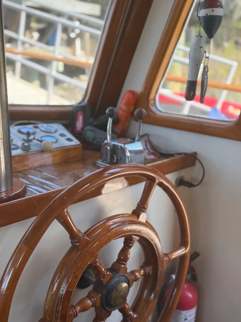 Slide: The Image of 1979 Marine Trader Double Cabin helm with wooden wheel and control panel. - 14