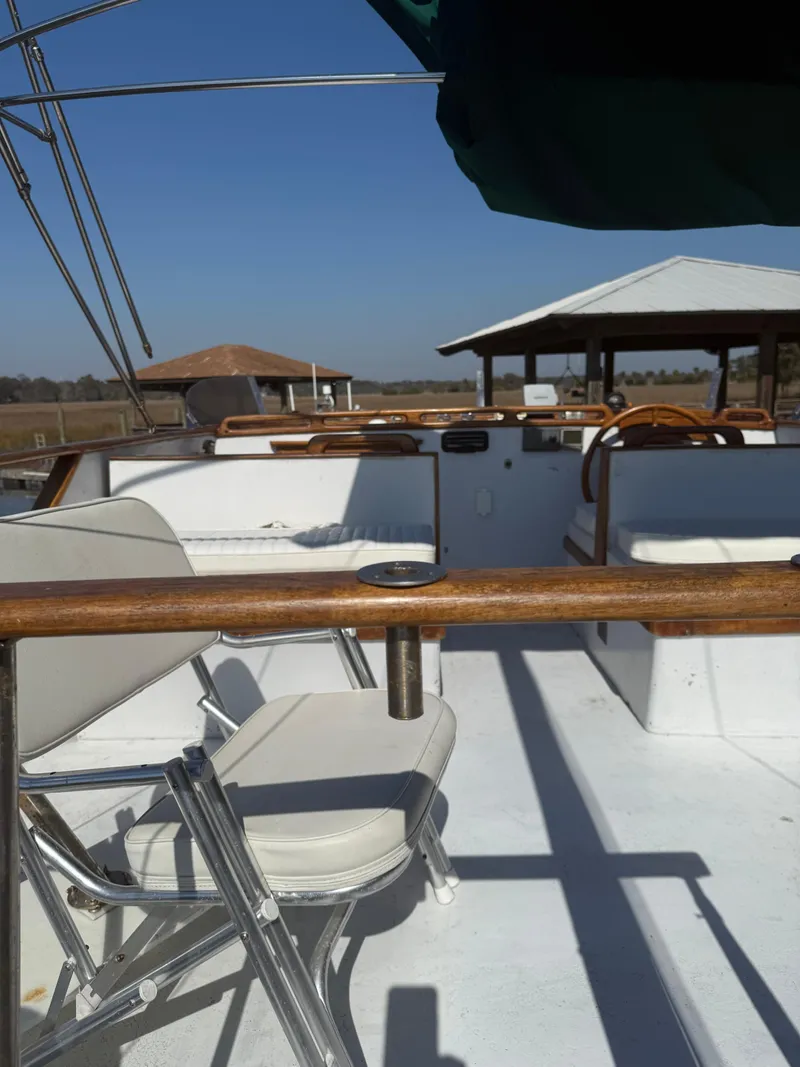 Slide: The Image of 1979 Marine Trader Double Cabin boat deck with seating and steering wheel. - 16