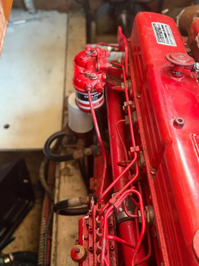 Slide: The Image of Engine of a 1979 Marine Trader Double Cabin boat, featuring red components and wiring. - 20