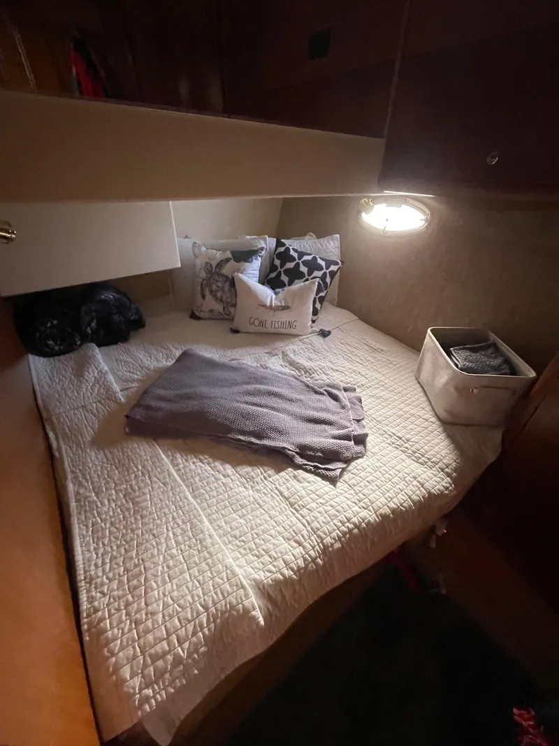 Slide: The Image of Cozy cabin interior of 2007 Silverton 38 Convertible yacht with bed and soft lighting. - 21