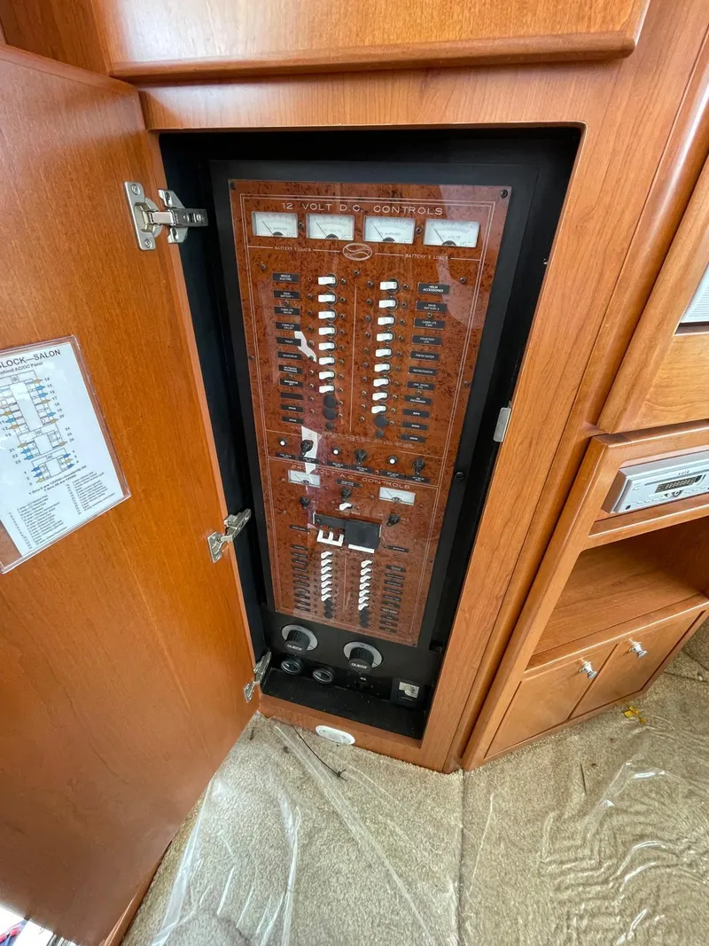 Slide: The Image of Electrical panel inside 2007 Silverton 38 Convertible boat, showcasing circuit breakers and controls. - 24
