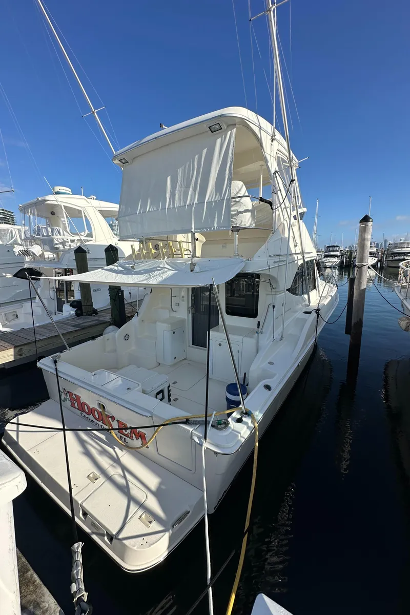 Slide: The Image of 2007 Silverton 38 Convertible yacht docked at marina under clear blue sky. - 33