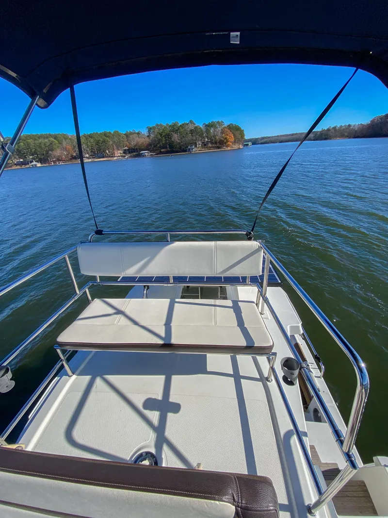 Slide: The Image of 2017 Ranger Tugs R-29 CB boat on a serene lake with clear blue skies. - 11