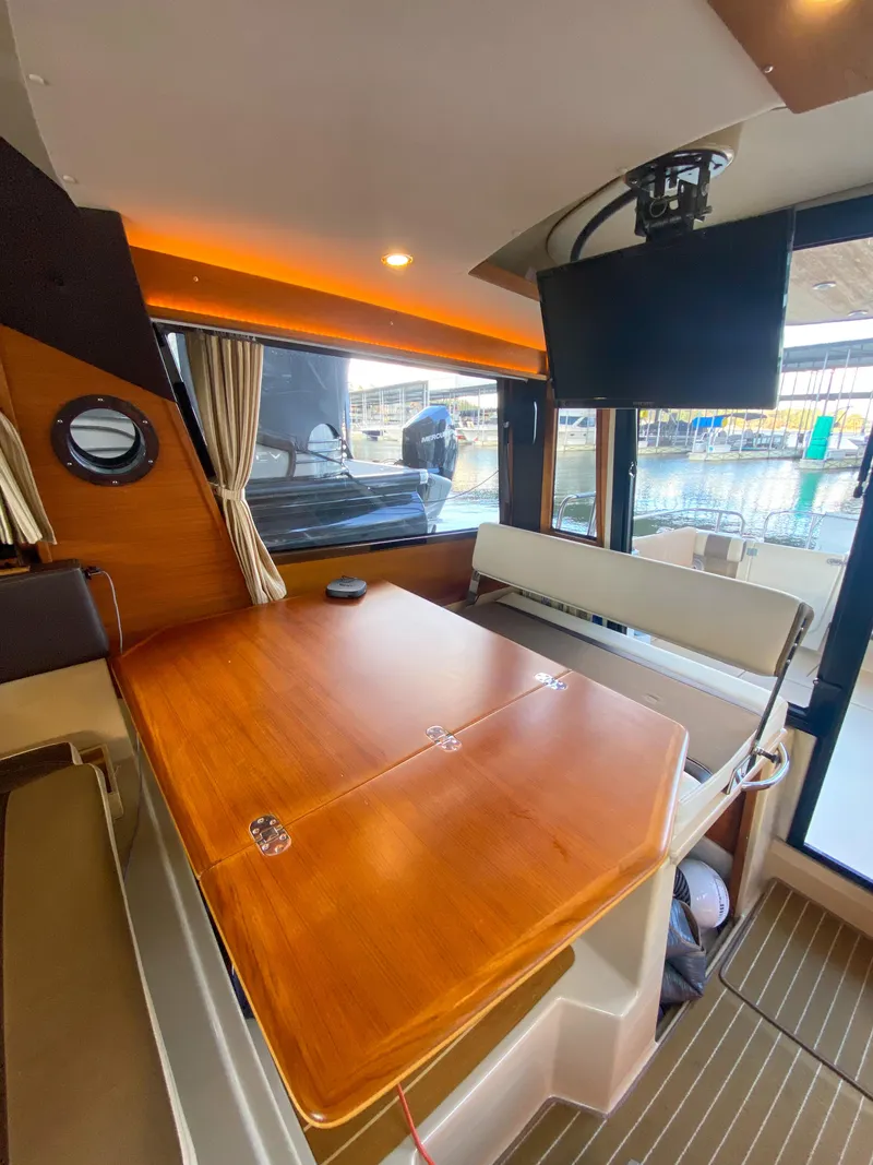 Slide: The Image of Interior of 2017 Ranger Tugs R-29 CB with wooden table and mounted TV. - 17