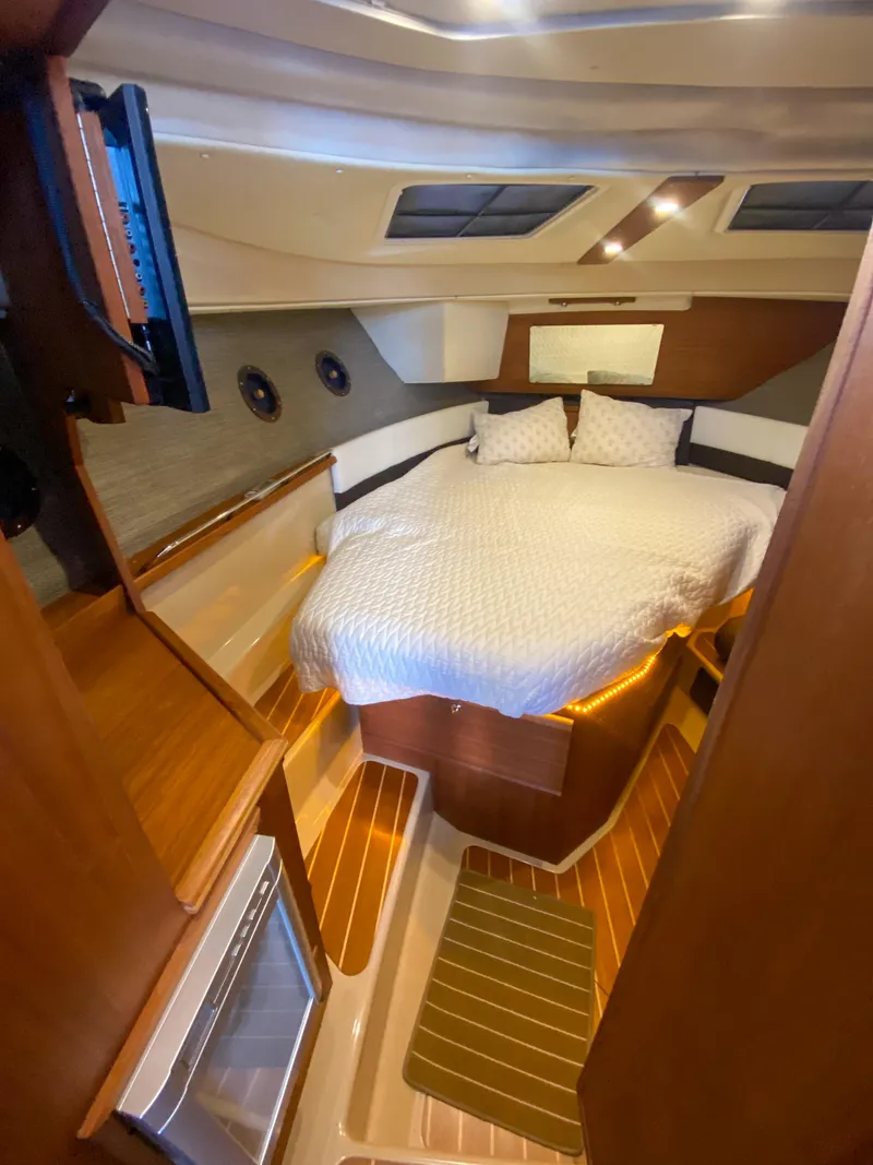 Slide: The Image of 2017 Ranger Tugs R-29 CB cabin interior with cozy bed and wood accents. - 21