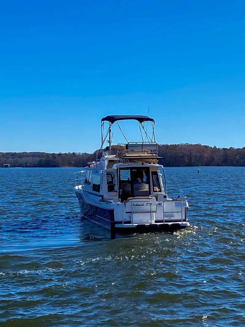 Slide: The Image of 2017 Ranger Tugs R-29 CB cruising on a serene lake under a clear blue sky. - 5