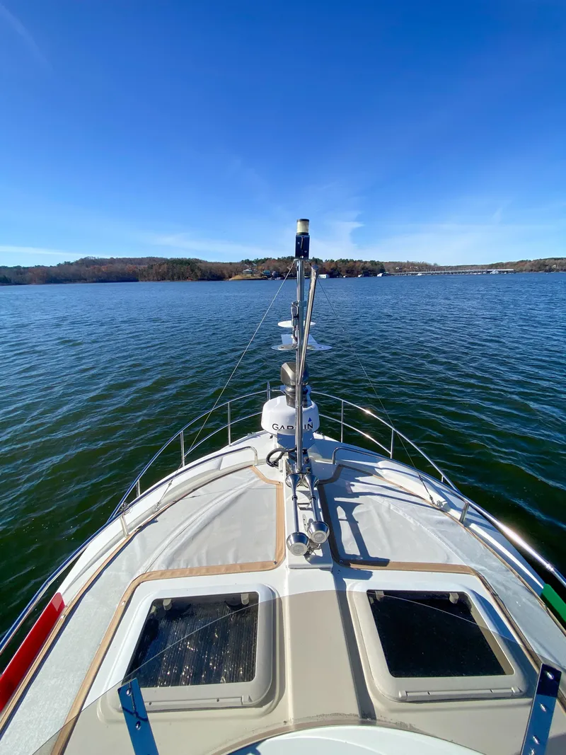 Slide: The Image of 2017 Ranger Tugs R-29 CB cruising on a serene lake under clear blue skies. - 9