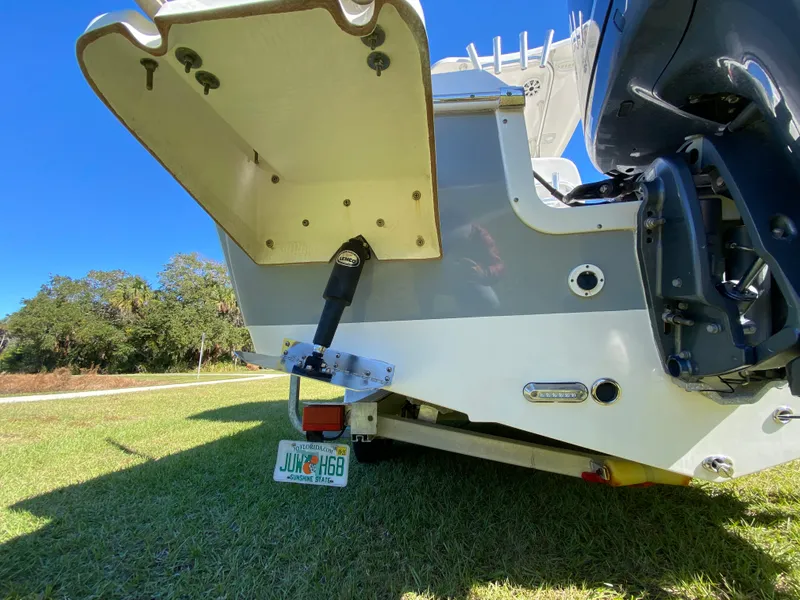 Slide: The Image of 2018 Tidewater 2400 Bay Max boat rear view on grass, showcasing motor and hull details. - 15