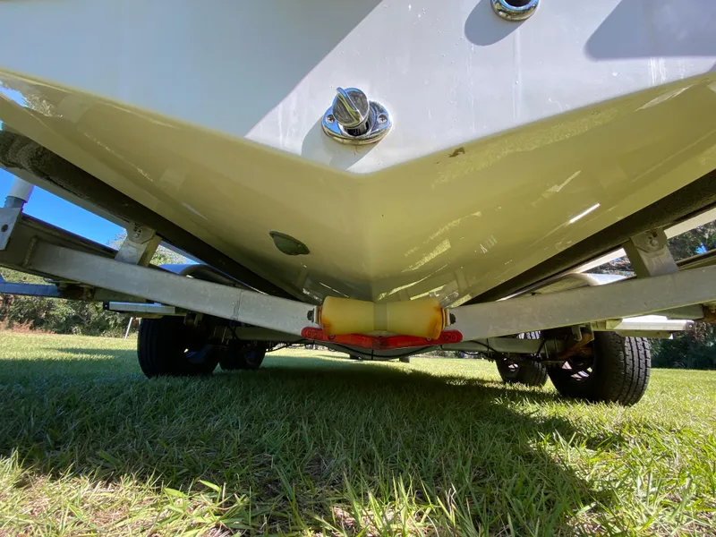 Slide: The Image of 2018 Tidewater 2400 Bay Max boat on trailer, viewed from below, resting on grass. - 18