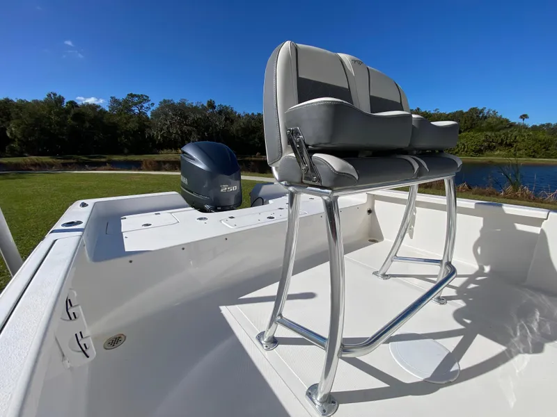 Slide: The Image of 2018 Tidewater 2400 Bay Max boat with seating and outboard motor, near a scenic waterway. - 24