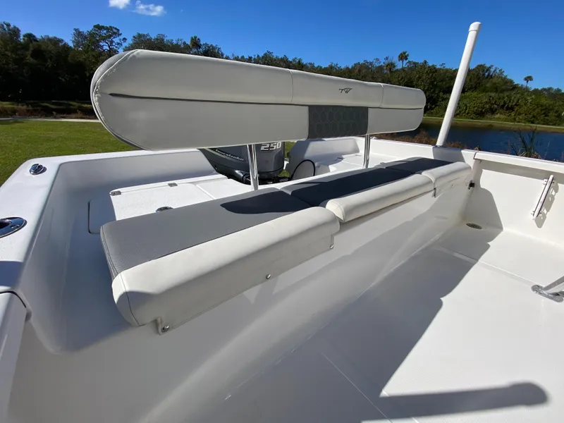 Slide: The Image of 2018 Tidewater 2400 Bay Max boat interior with cushioned seating and scenic outdoor view. - 33