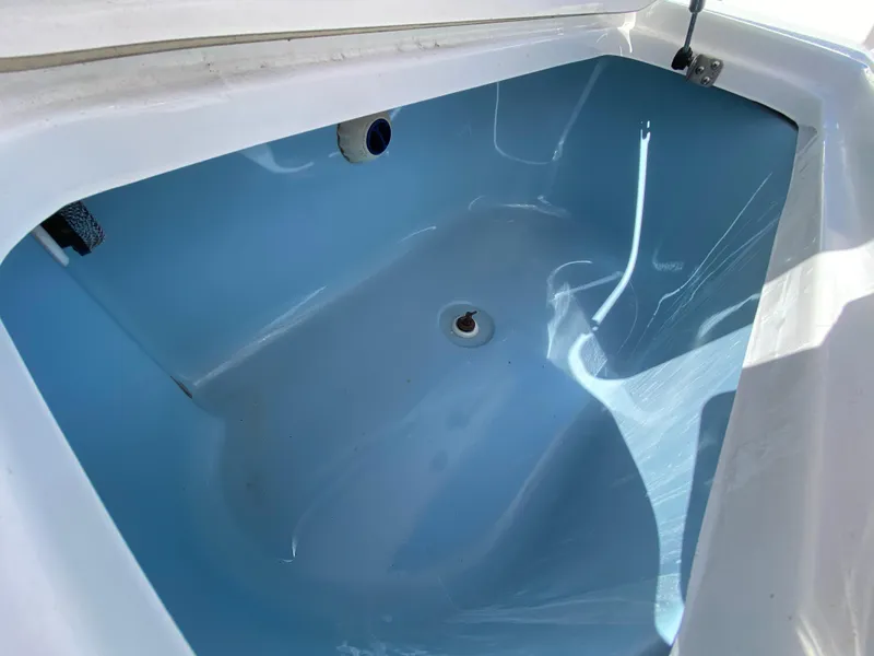 Slide: The Image of 2018 Tidewater 2400 Bay Max boat interior compartment, featuring a clean, blue finish. - 43