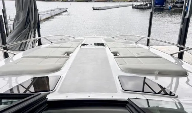 Slide: The Image of 2017 Cobalt A40 boat deck with sun loungers, docked by a serene waterfront. - 8