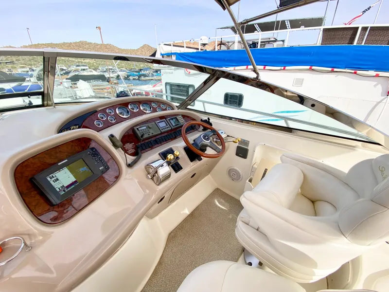 Slide: The Image of Cockpit of 2000 Sea Ray 380 Sundancer with modern navigation equipment and plush seating. - 12