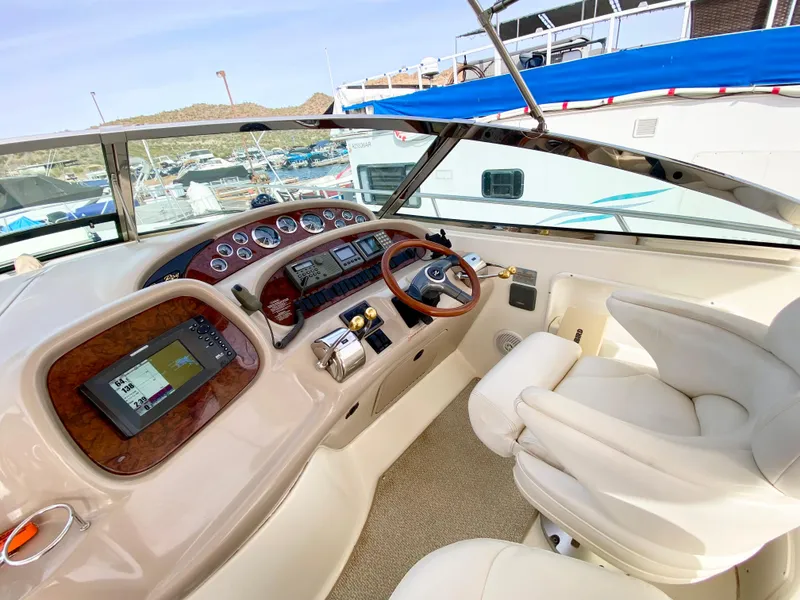 Slide: The Image of Cockpit of 2000 Sea Ray 380 Sundancer with modern navigation controls and plush seating. - 13