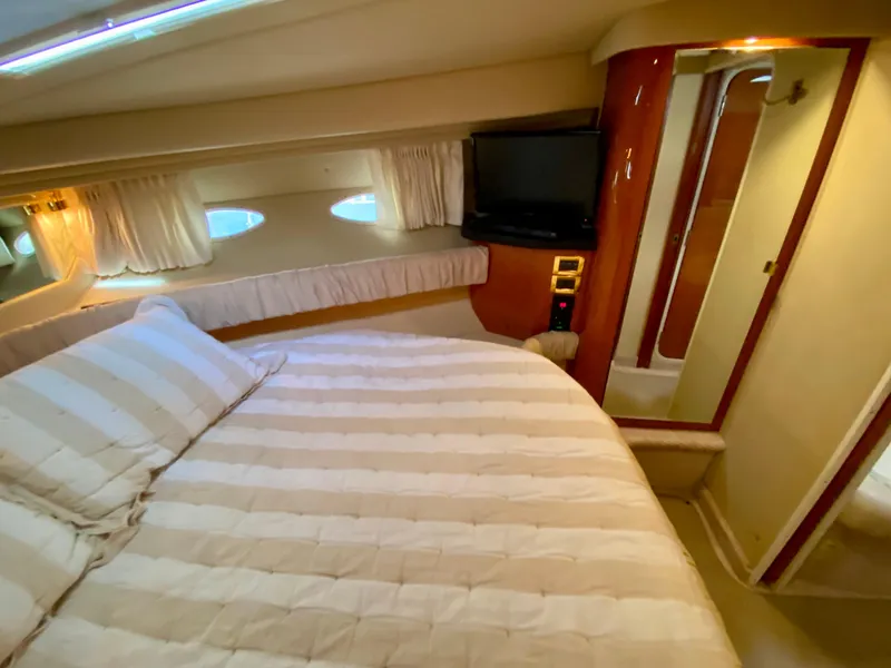 Slide: The Image of Luxurious cabin interior of 2000 Sea Ray 380 Sundancer yacht with cozy bed and TV. - 29