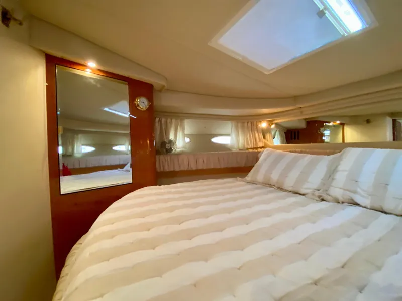 Slide: The Image of Cozy bedroom interior of 2000 Sea Ray 380 Sundancer yacht with striped bedding. - 30