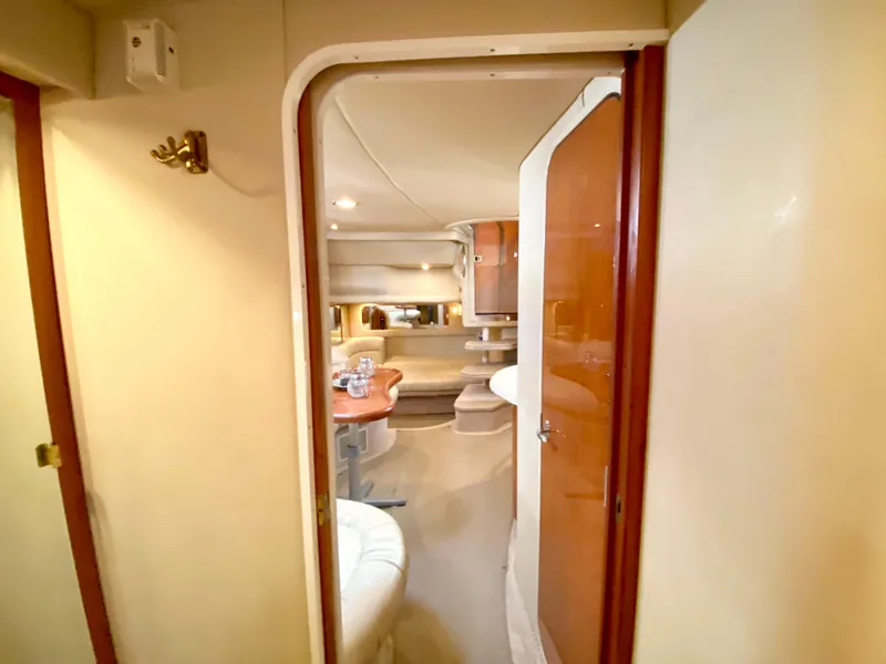 Slide: The Image of Interior view of 2000 Sea Ray 380 Sundancer yacht, featuring cozy seating and wooden cabinetry. - 32