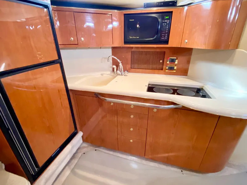 Slide: The Image of 2000 Sea Ray 380 Sundancer yacht kitchen with wood cabinets, microwave, and stove. - 41