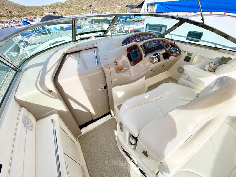 Slide: The Image of 2000 Sea Ray 380 Sundancer cockpit with white leather seats and control panel. - 9