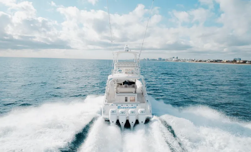 Slide: The Image of Boston Whaler 420 Outrage 2017 cruising on open sea with city skyline in background. - 1