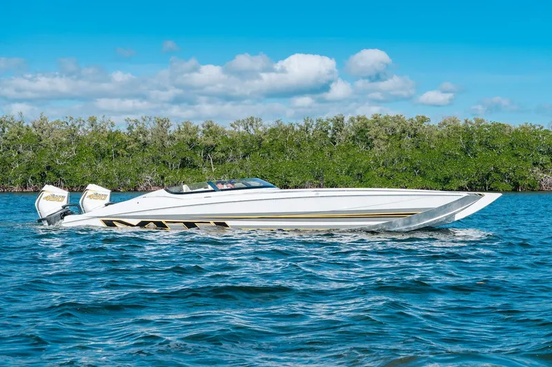 Slide: The Image of 2022 MTI 390X speedboat cruising on a sunny day with lush greenery in the background. - 7