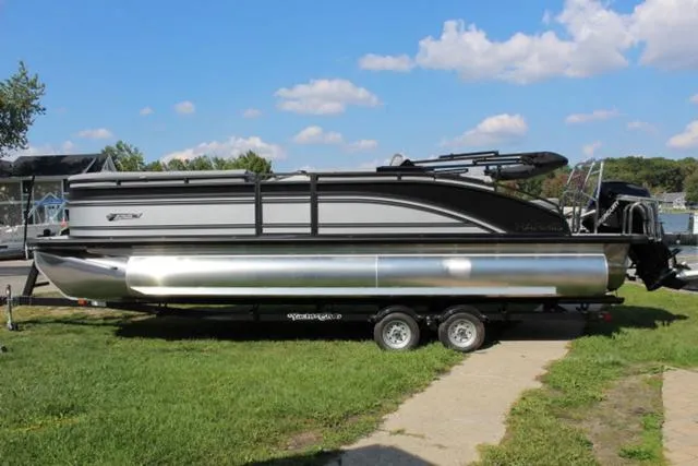 Slide: The Image of 2024 Harris Solstice 250 SL pontoon boat on trailer, parked on grass under blue sky. - 3