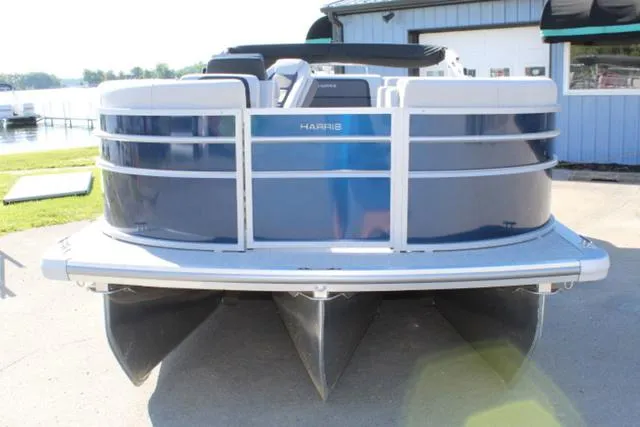 Slide: The Image of 2024 Harris Cruiser 230 CS pontoon boat, docked, front view, blue and white design. - 8