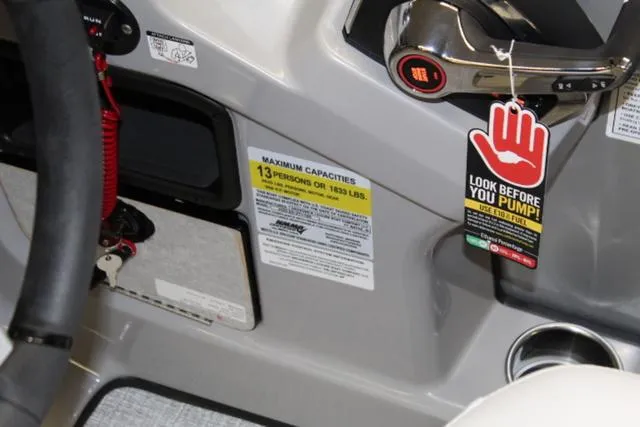 Slide: The Image of 2024 Harris Sunliner 250 SLDH boat dashboard with capacity warning and safety tag. - 18