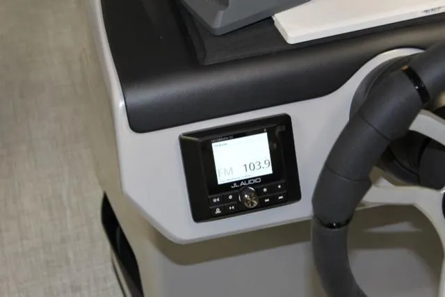 Slide: The Image of 2024 Harris Sunliner 250 SLDH dashboard with JL Audio system displaying FM 103.9. - 19