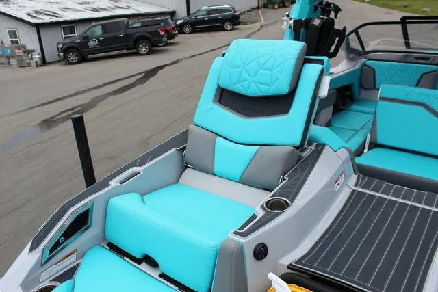 Slide: The Image of 2022 Nautique G23 Paragon boat with turquoise and gray seating, docked outdoors. - 29
