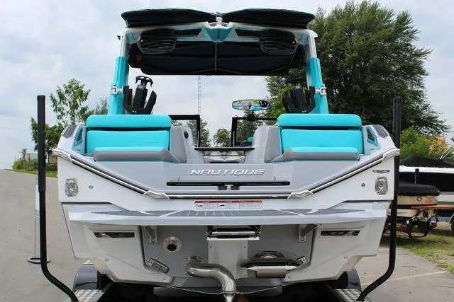 Slide: The Image of 2022 Nautique G23 Paragon boat with teal seating, rear view. - 4