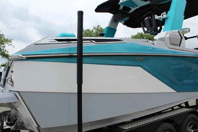 Slide: The Image of 2022 Nautique G23 Paragon boat with sleek blue and white design on a trailer. - 8