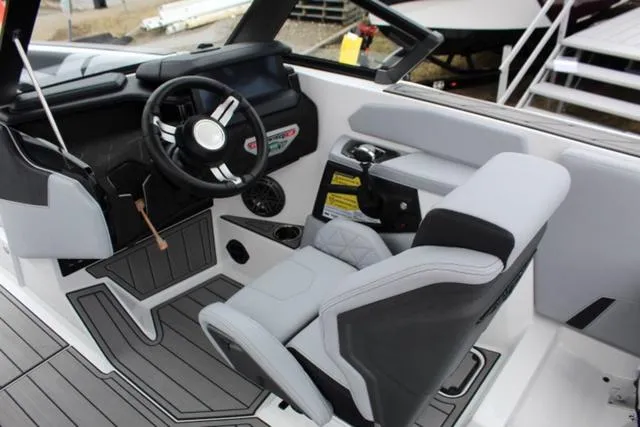 Slide: The Image of 2024 Nautique Super Air Nautique GS22 interior with modern helm and seating. - 25