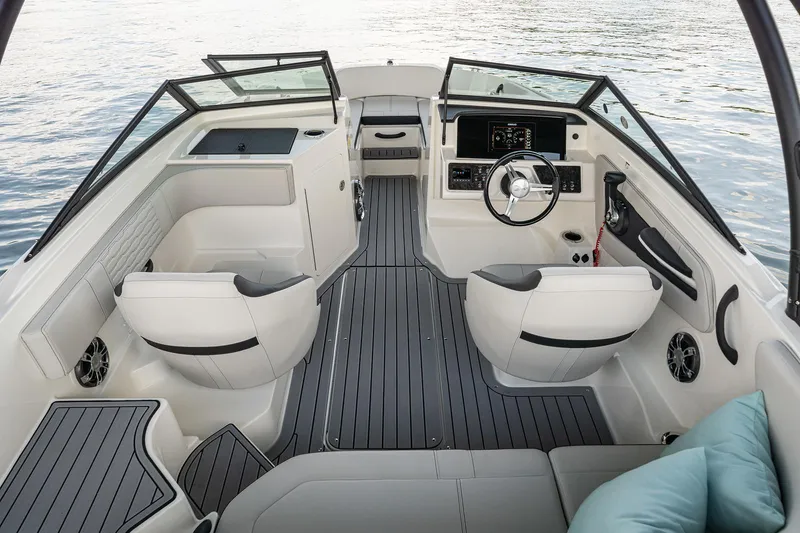 Slide: The Image of 2023 Sea Ray SPX 190 boat interior with modern dashboard and seating, on calm water. - 11