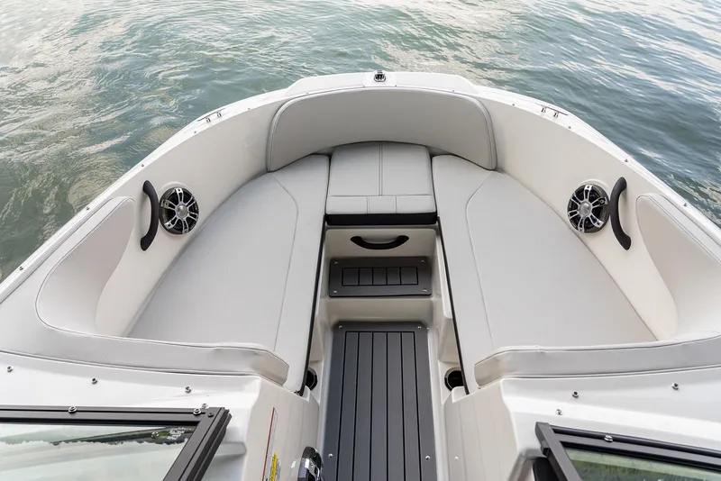 Slide: The Image of 2023 Sea Ray SPX 190 boat interior with cushioned seating and speakers on calm water. - 17