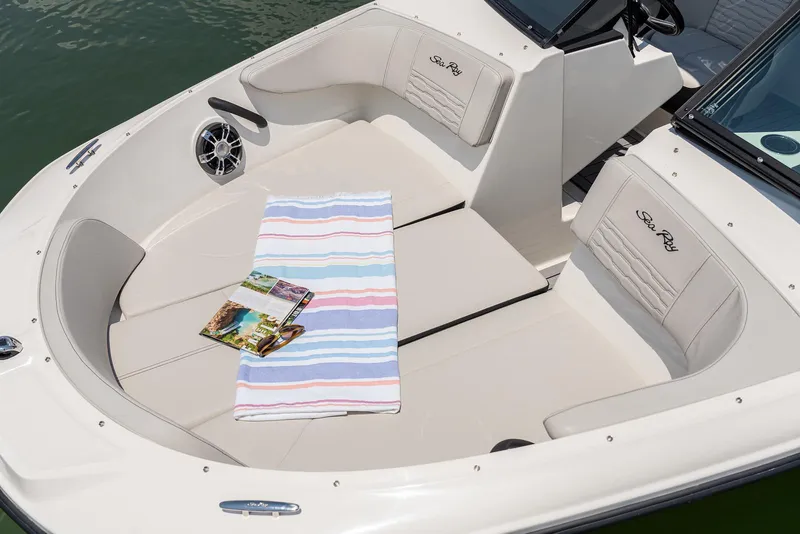 Slide: The Image of 2023 Sea Ray SPX 190 boat interior with striped towel and magazine on seats. - 18