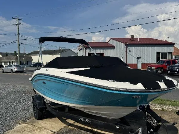 Slide: The Image of 2023 Sea Ray SPX 190 boat with blue hull and black cover on a trailer. - 4