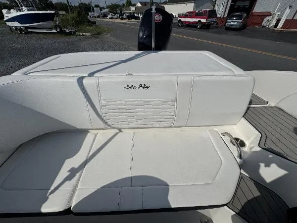 Slide: The Image of 2023 Sea Ray SPX 190 boat with white seating and logo, parked outdoors. - 5