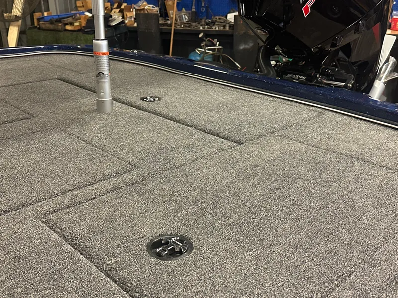 Slide: The Image of 2025 Nitro Z21 XL Pro boat deck with gray carpet and fishing rod holder. - 16