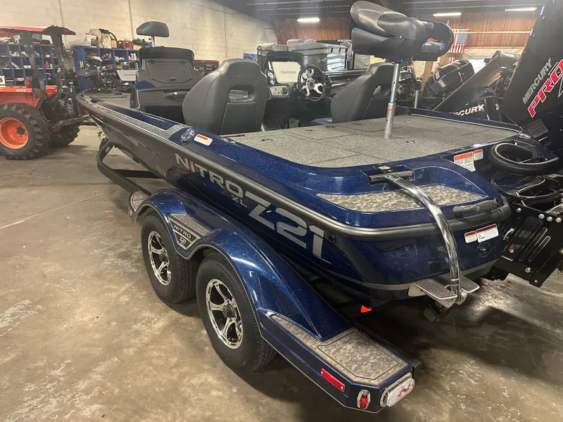 Slide: The Image of 2025 Nitro Z21 XL Pro boat in showroom, featuring sleek design and dual-axle trailer. - 5
