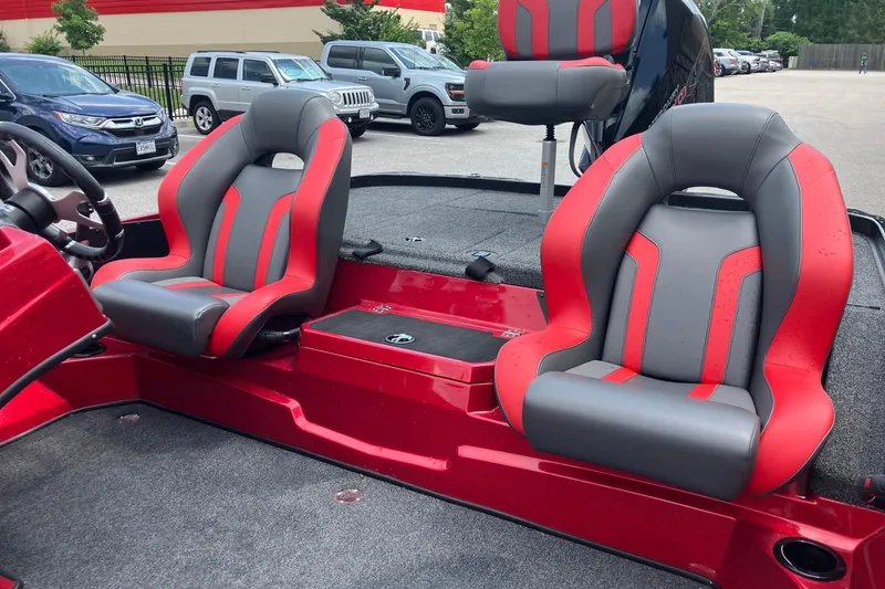 Slide: The Image of Red and gray seats in a 2025 Nitro Z19 boat, parked in a lot. - 6
