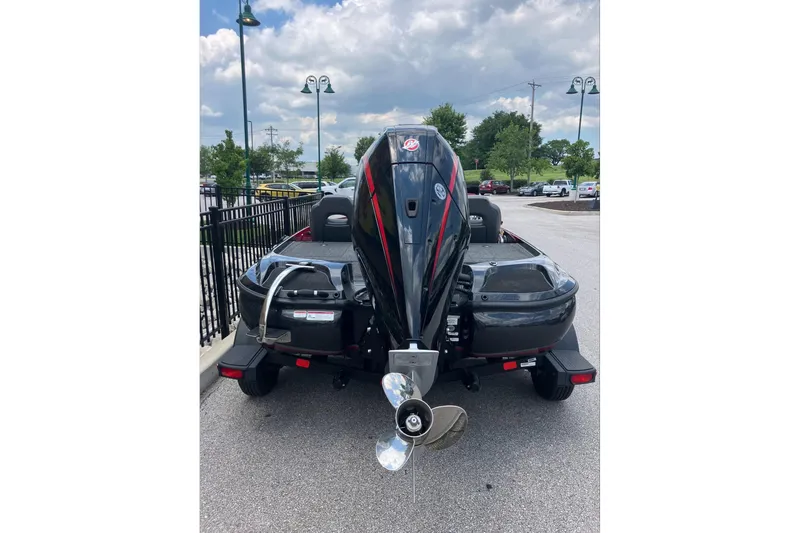 Slide: The Image of 2025 Nitro Z19 boat with powerful outboard motor, parked outdoors under cloudy sky. - 2