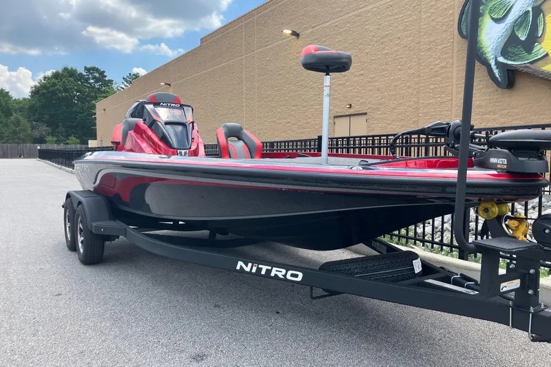 Slide: The Image of 2025 Nitro Z19 boat on trailer, red and black design, parked outdoors. - 4