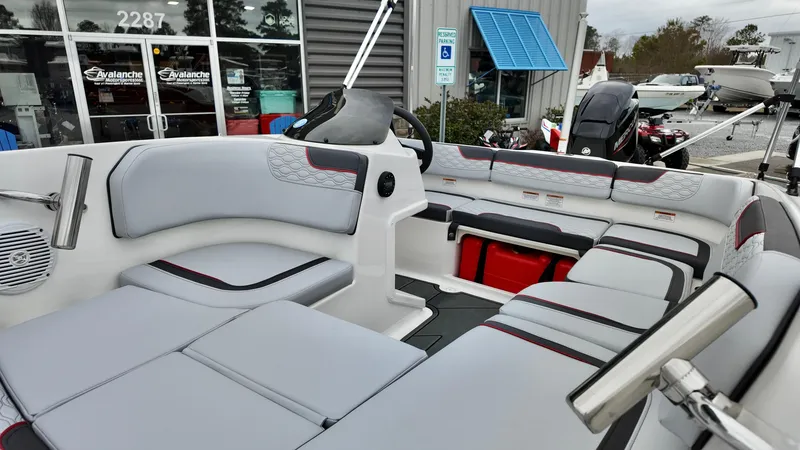 Slide: The Image of 2025 Bayliner M15 boat interior with modern seating and steering wheel, displayed at a dealership. - 10